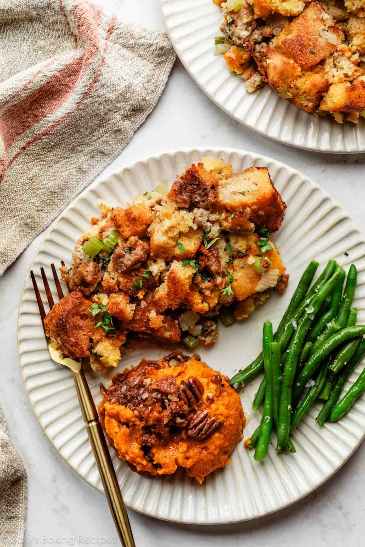 plate of Thanksgiving sides including sweet potato casserole and cornbread stuffing.