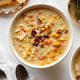 bowl of creamy chicken and corn soup with bacon on top.