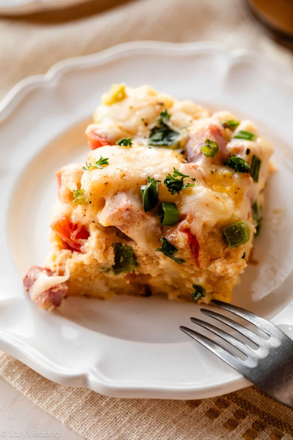 ham & swiss breakfast strata on white plate.