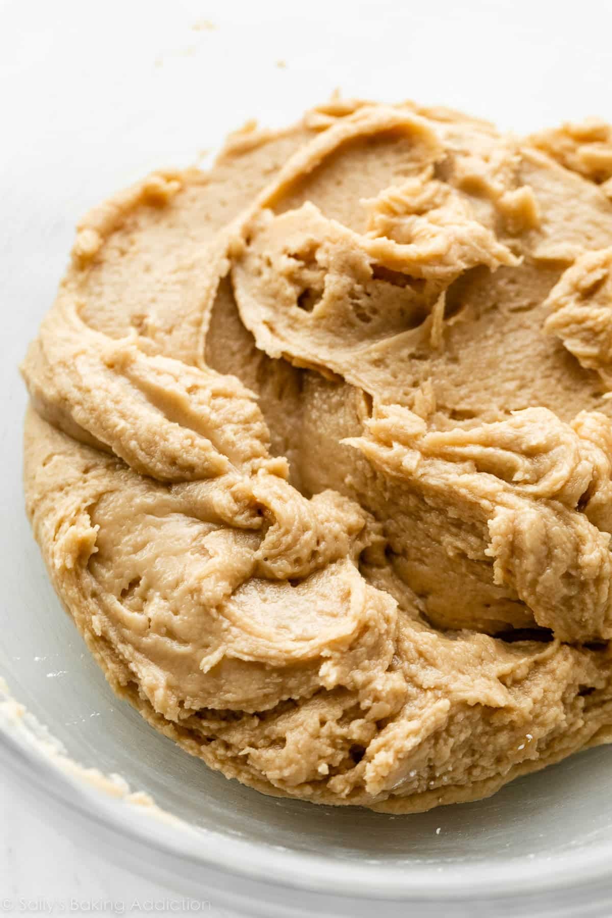 over-worked and separated frosting mixture in glass bowl.