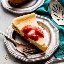 slices of cheesecake with strawberry topping on a silver plates with a fork