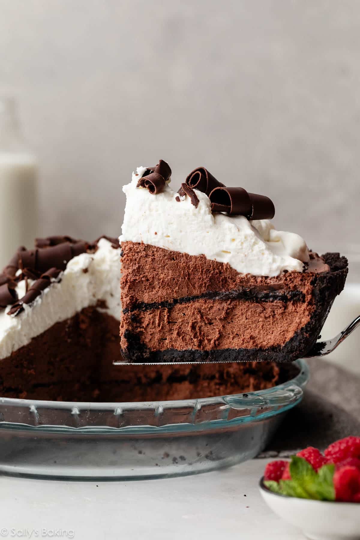 slice of sky-high chocolate mousse pie being removed from pie dish.