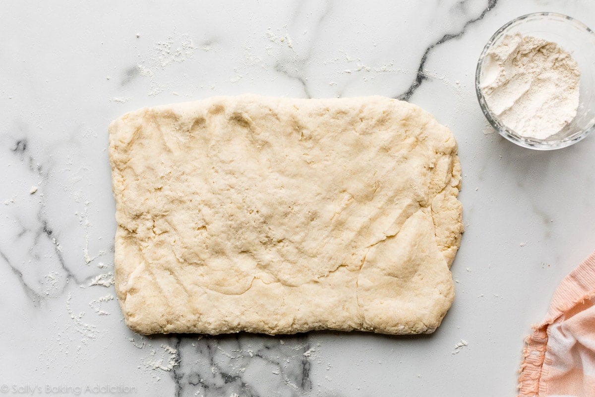 flattened dough on marble counter
