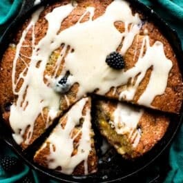 overhead image of blackberry peach skillet cornmeal cake topped with brown butter icing