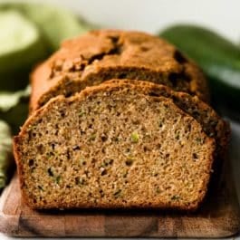 sliced loaf of zucchini bread on wooden cutting board