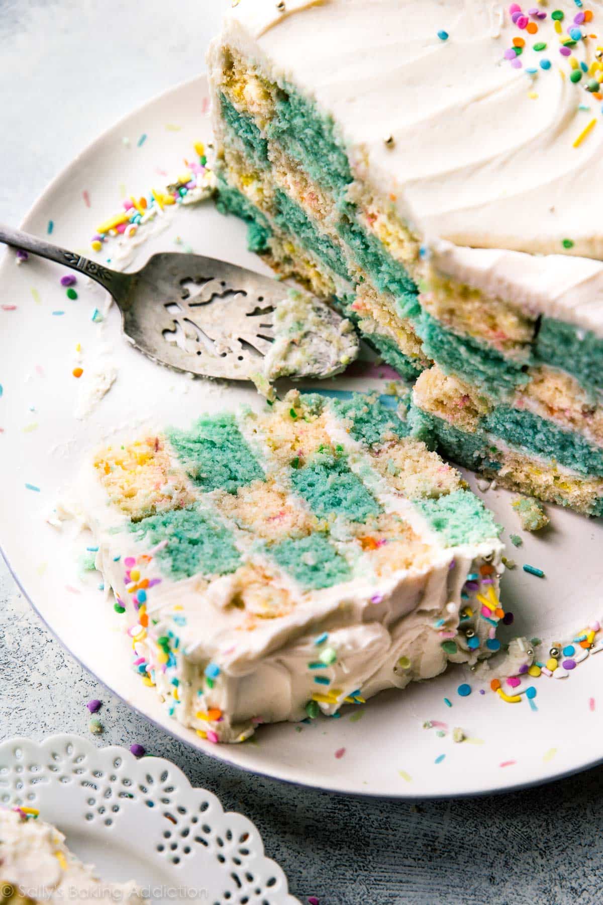 sliced checkerboard cake on a serving plate with a dessert server