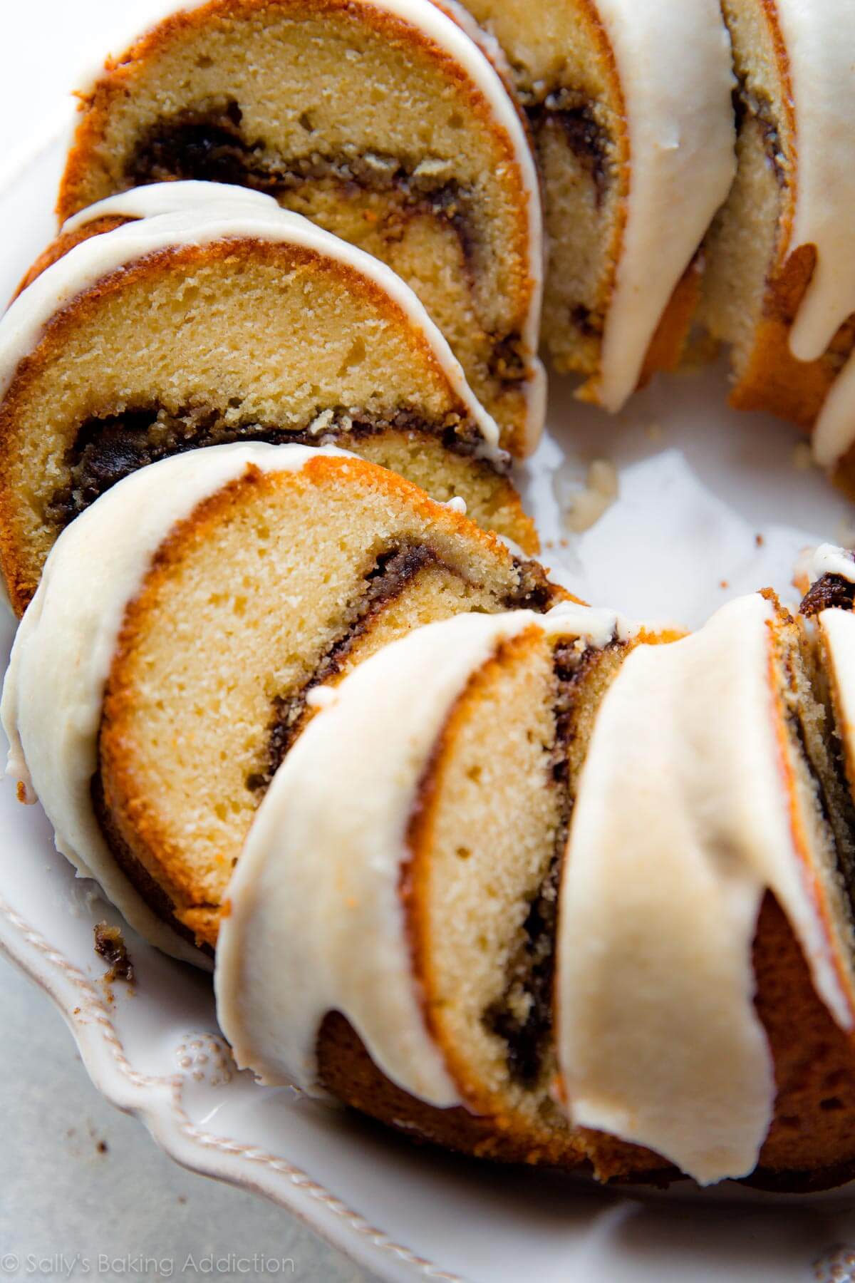 chai cinnamon swirl bundt cake on a white serving plate cut into slices