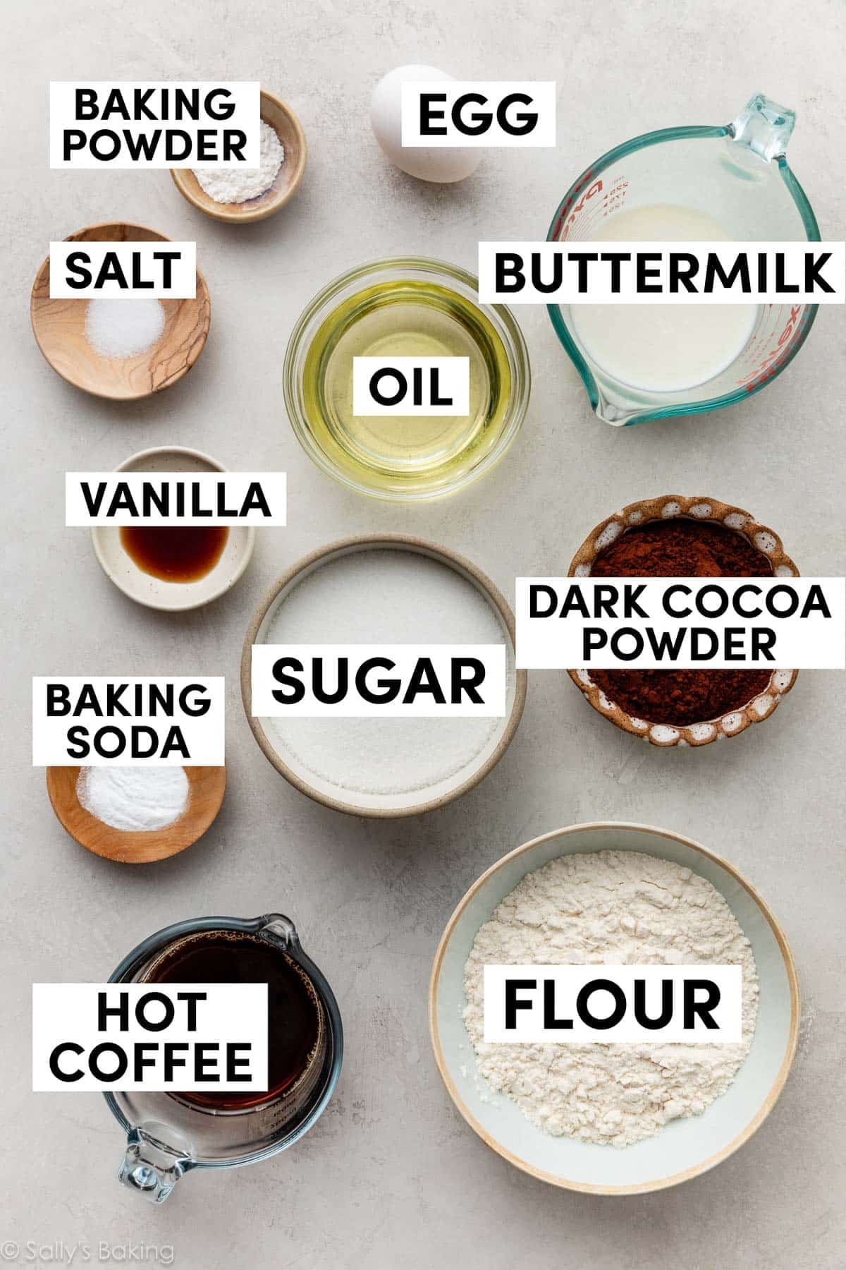 ingredients measured out in bowl including buttermilk, oil, sugar, dark cocoa powder, coffee, and flour.