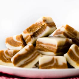 squares of gingerbread fudge stacked onto a white plate