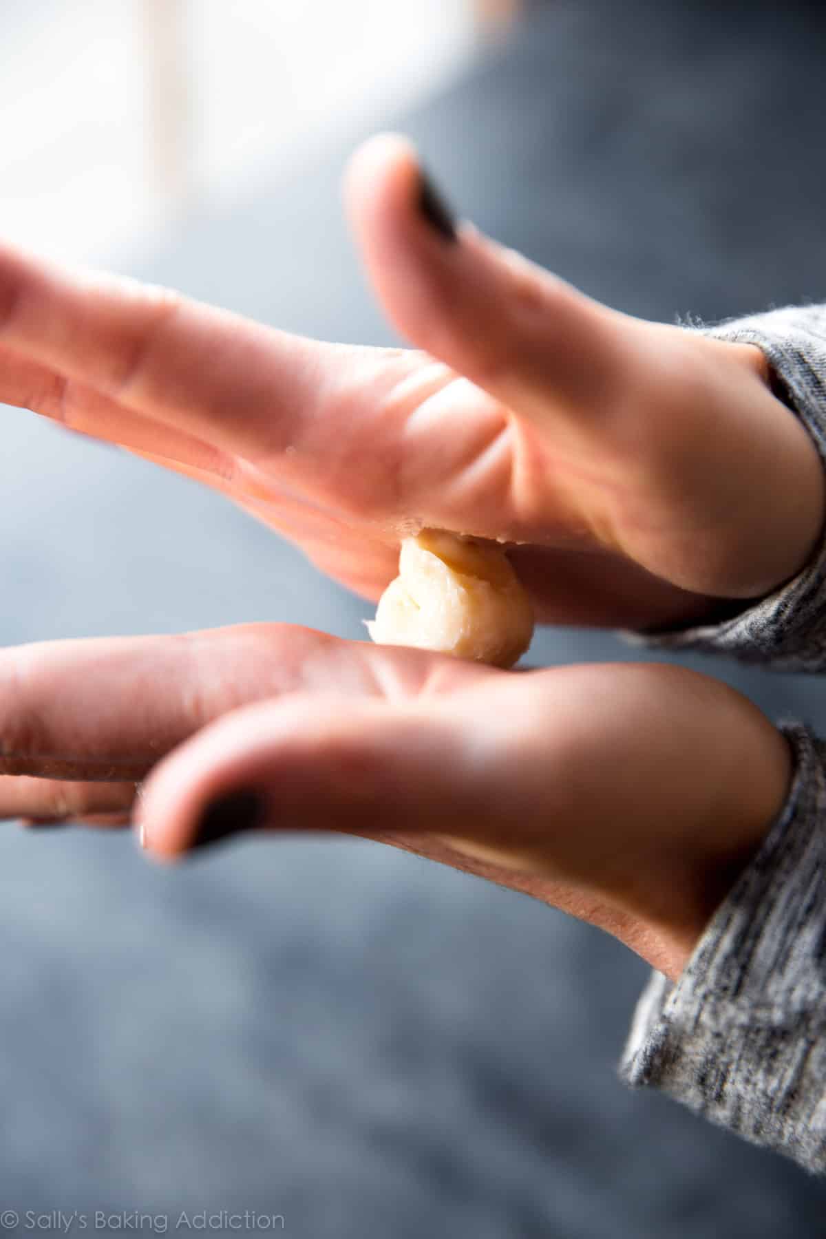 rolling cream cheese filling in between palms