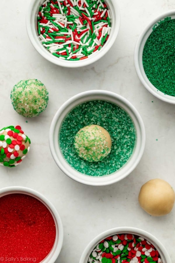 rolling cookie dough balls in green sprinkles.