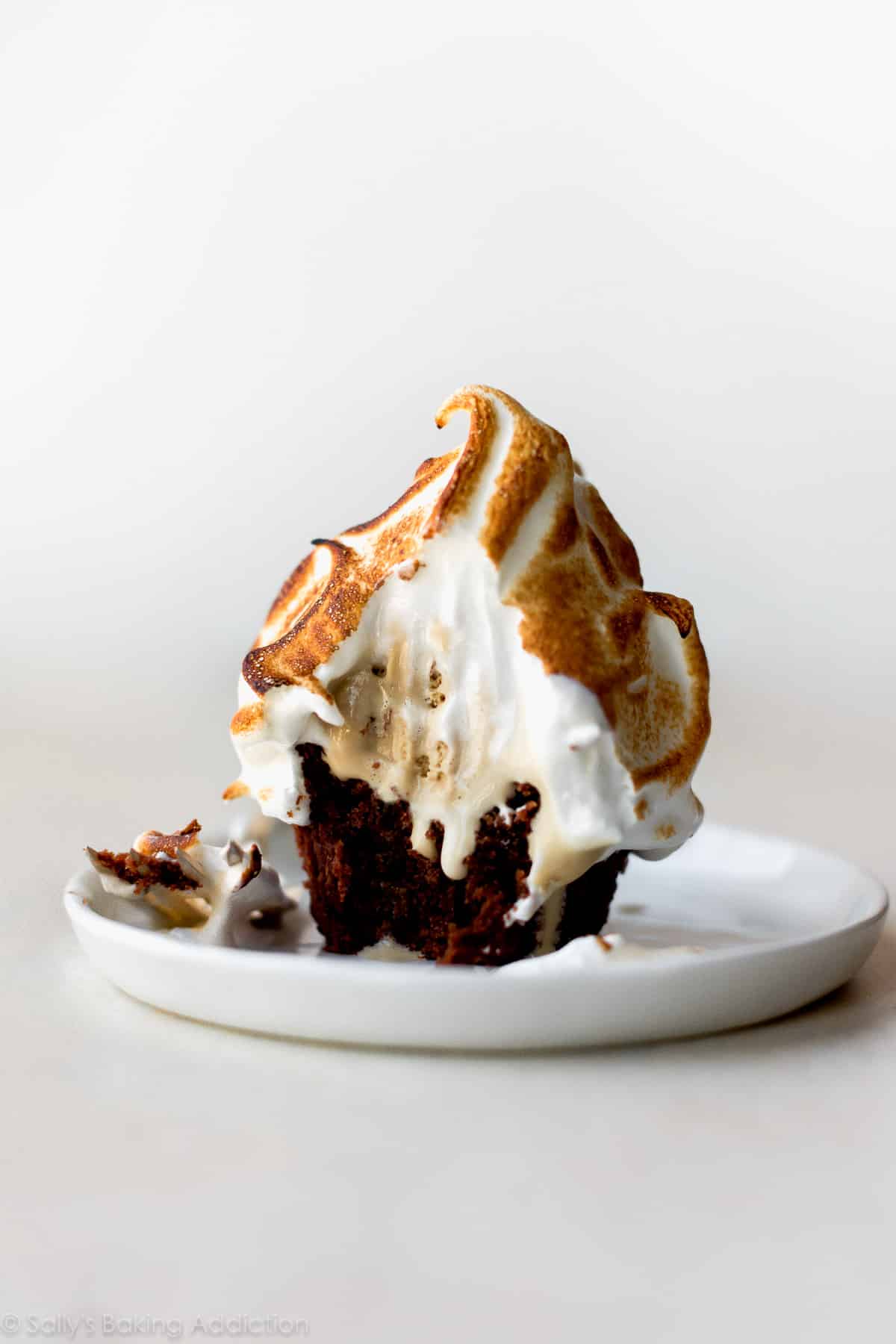 brownie baked Alaska cupcake on a white plate