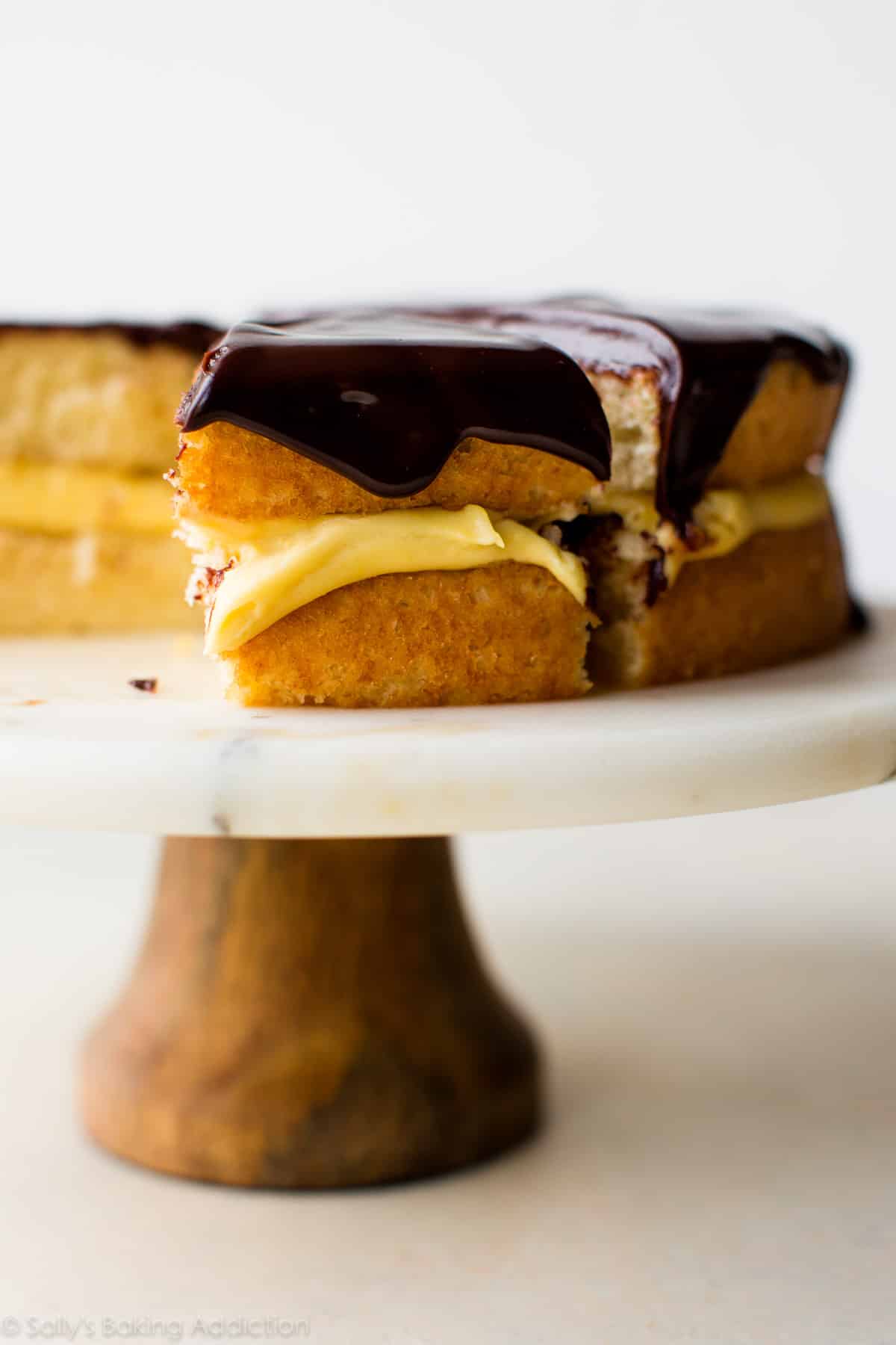 Boston cream pie on a wood and marble cake stand