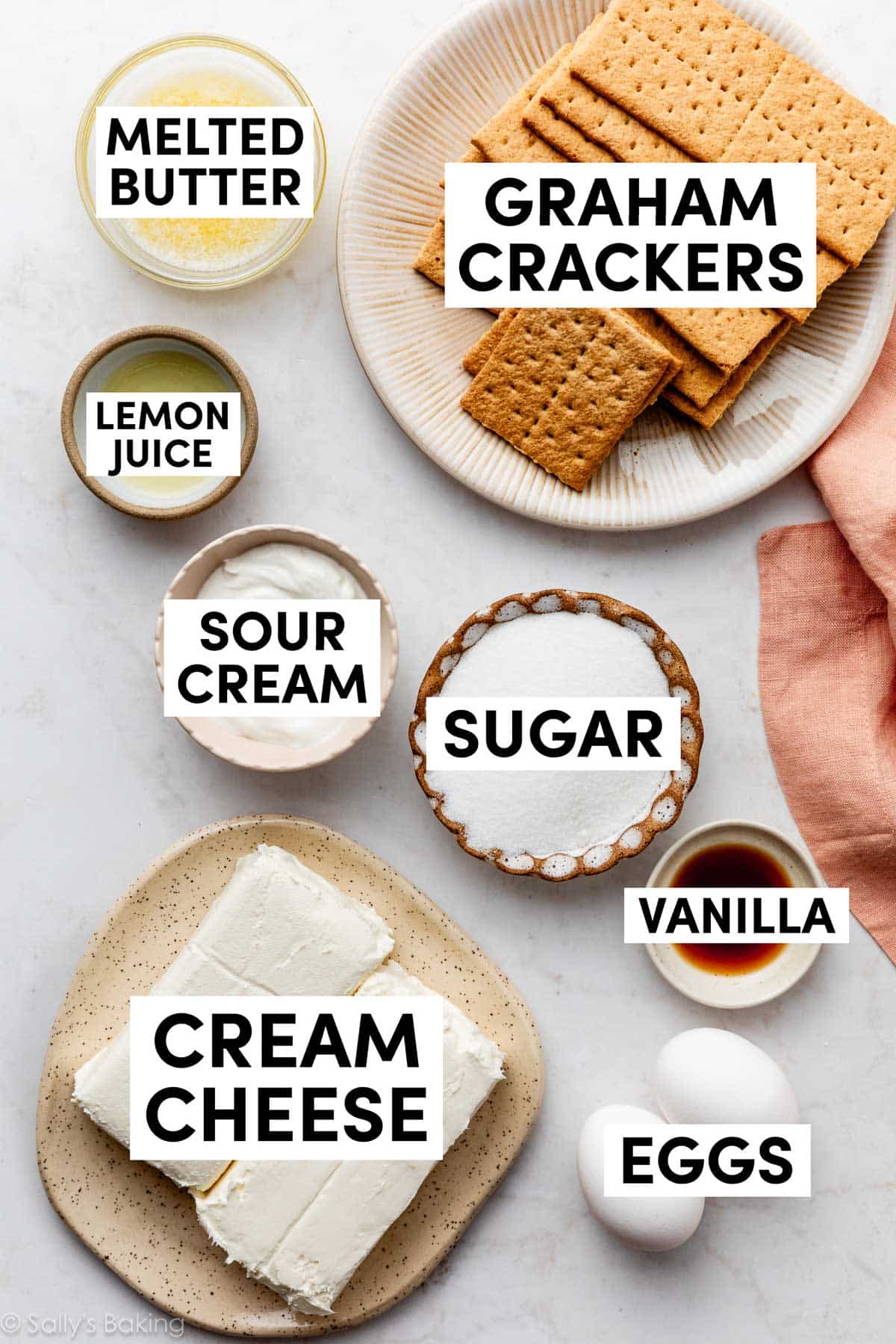 ingredients on counter including graham crackers, melted butter, sugar, sour cream, cream cheese.