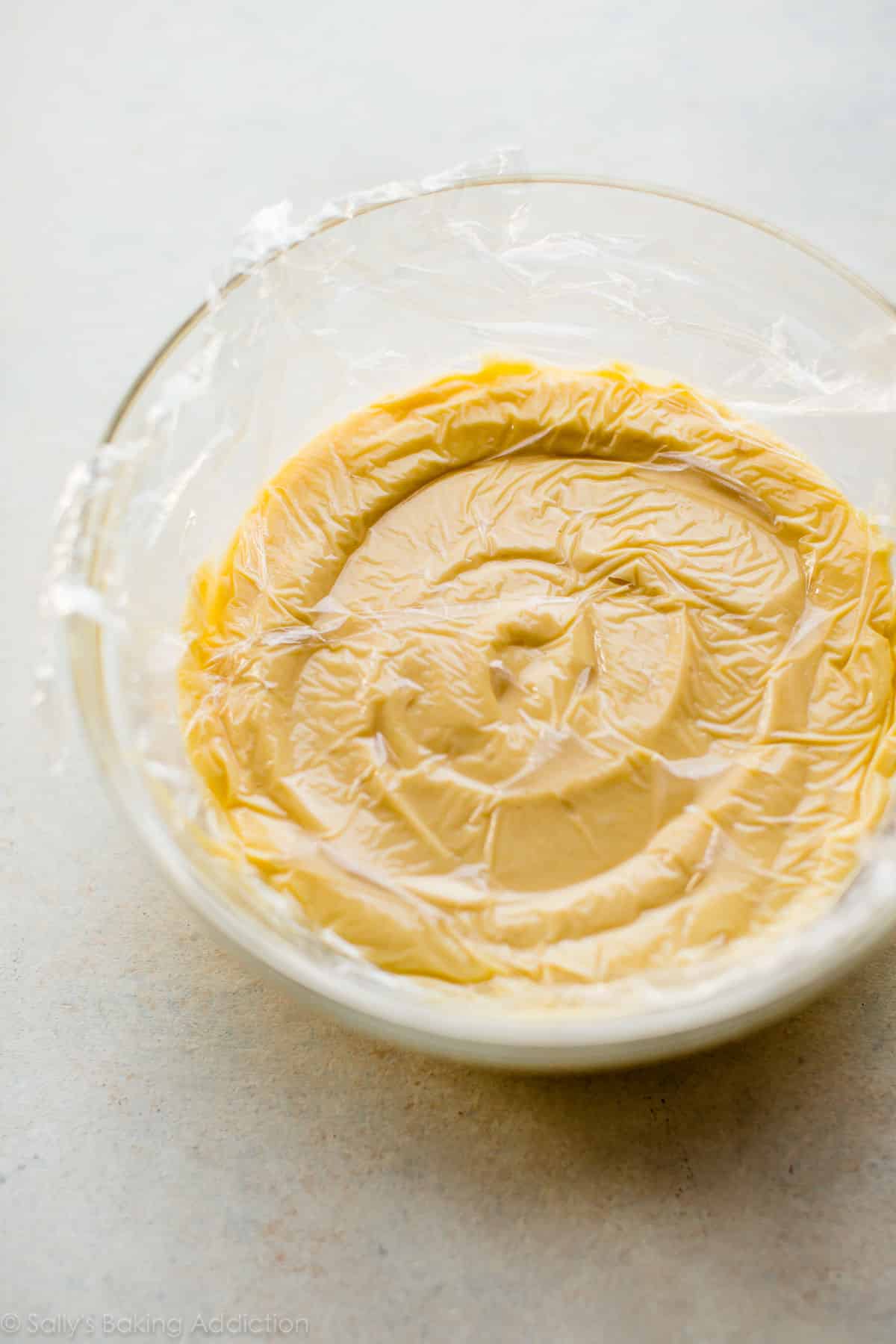 pastry cream in a glass bowl covered with plastic wrap