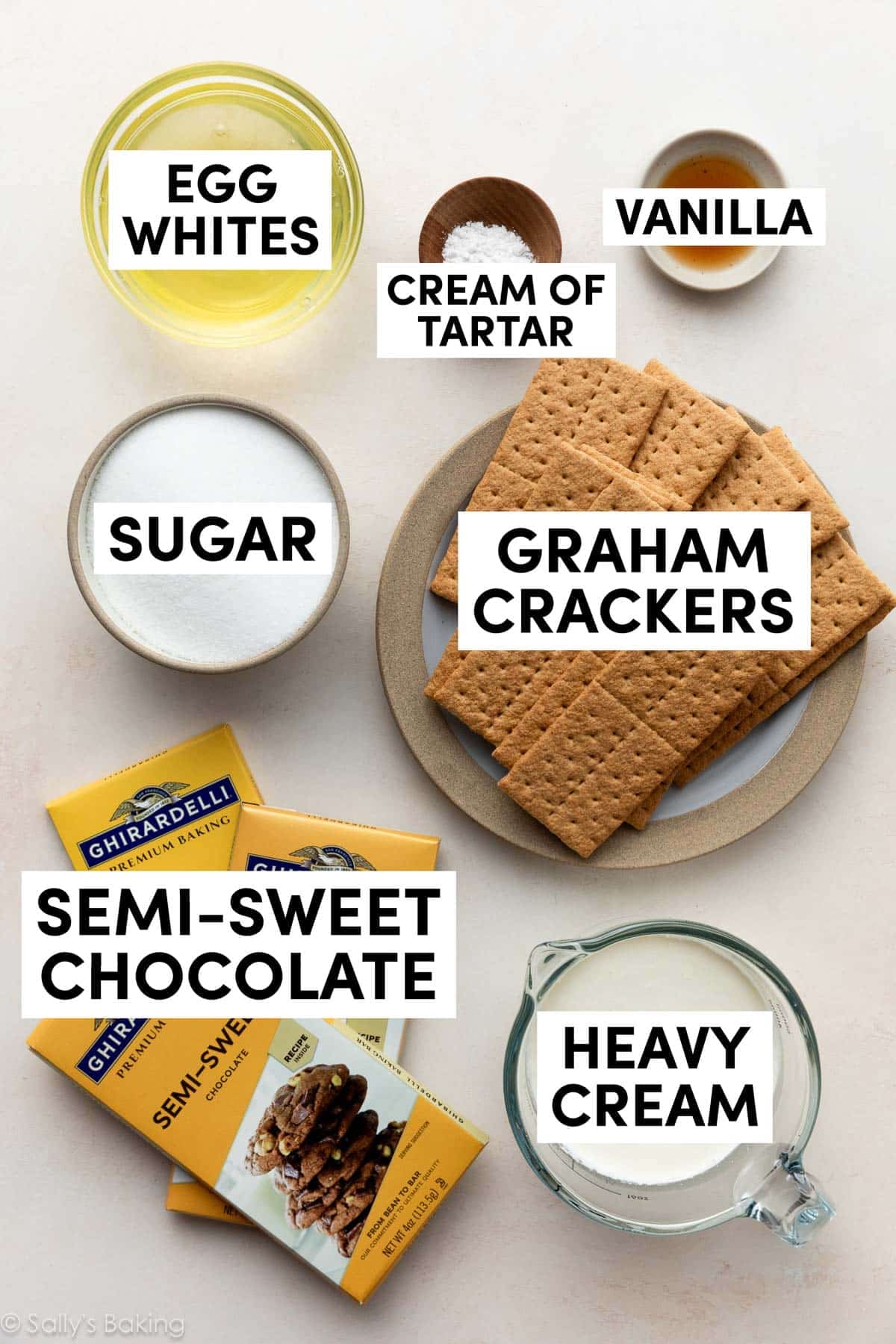 measured ingredients on surface including egg whites, cream of tartar, vanilla, sugar, chocolate, and heavy cream.