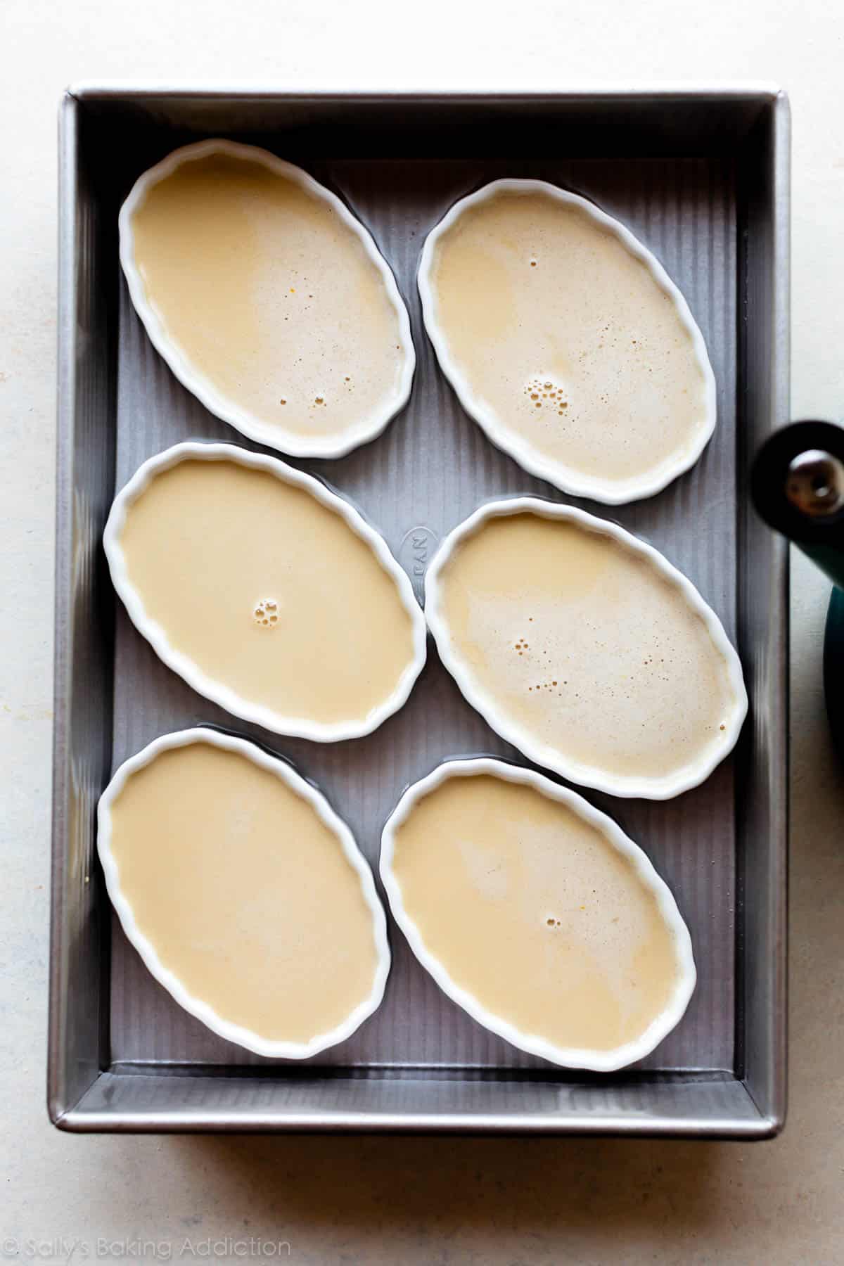 ramekins of creme brulee before baking in a water bath