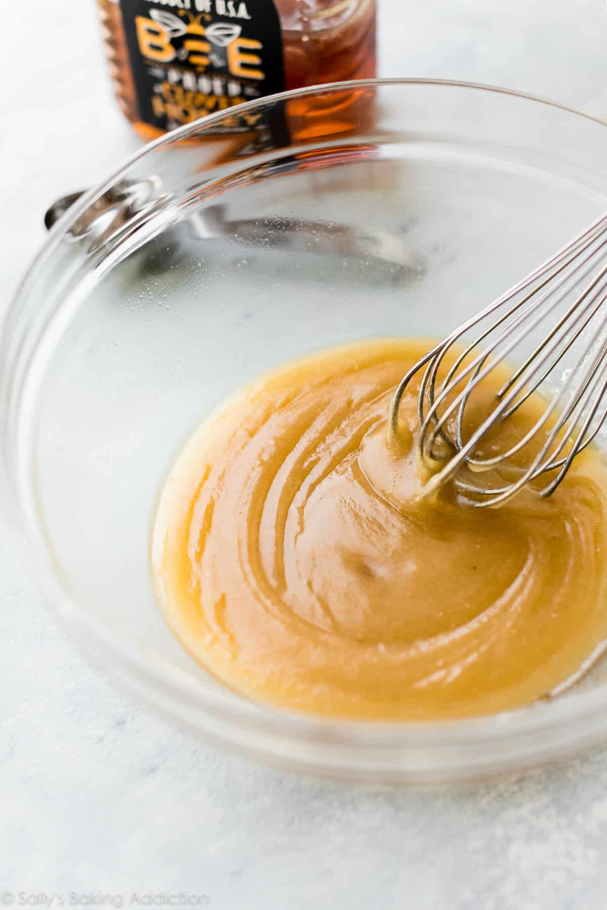 Wet ingredients in a glass bowl with a whisk