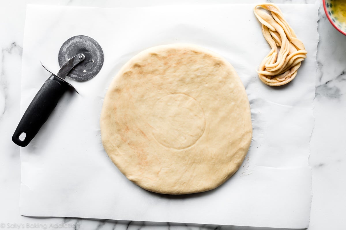 Star bread dough rolled into a circle on a piece of parchment paper