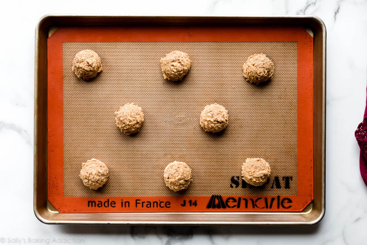Oatmeal cookie dough balls on baking sheet before baking