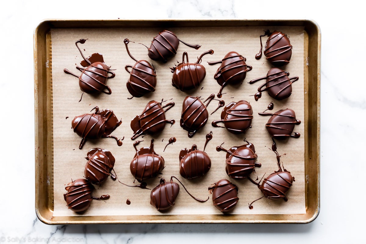 Chocolate covered buttercream Easter eggs on parchment lined baking sheet