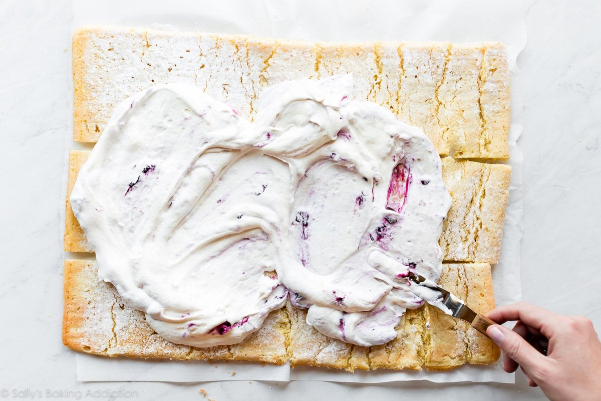 spreading whipped cream on vertical cake pieces