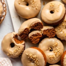 pumpkin donuts with brown sugar icing with crushed walnuts on top.