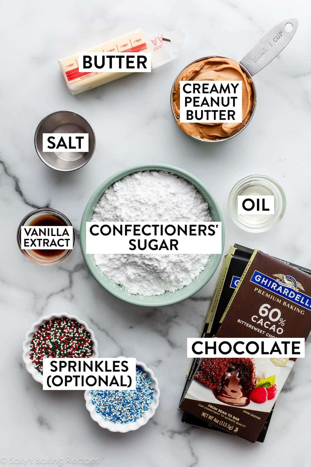 ingredients measured on marble counter including butter, salt, vanilla, chocolate, confectioners' sugar, and sprinkles.
