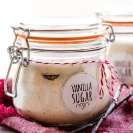 homemade vanilla sugar in a jar with vanilla beans on the side