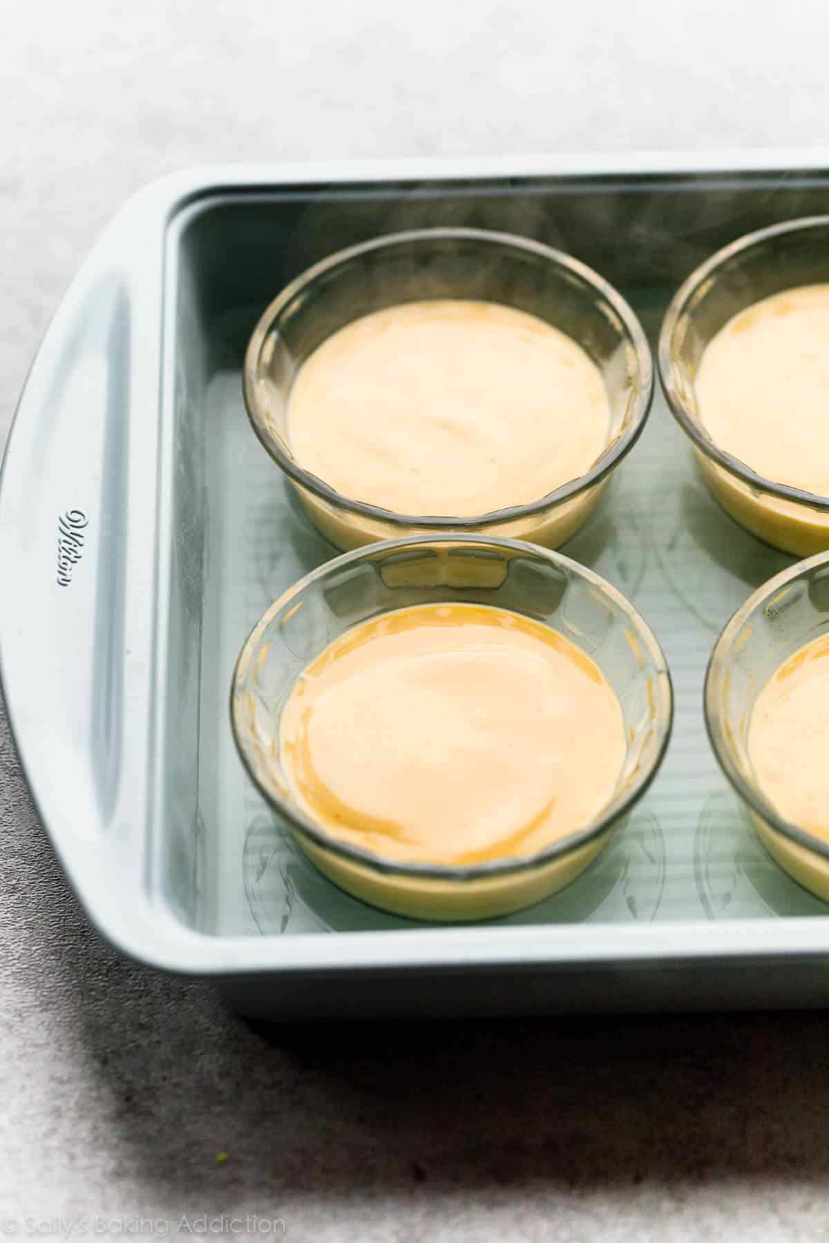 key lime pie filling in individual ramekins in a water bath