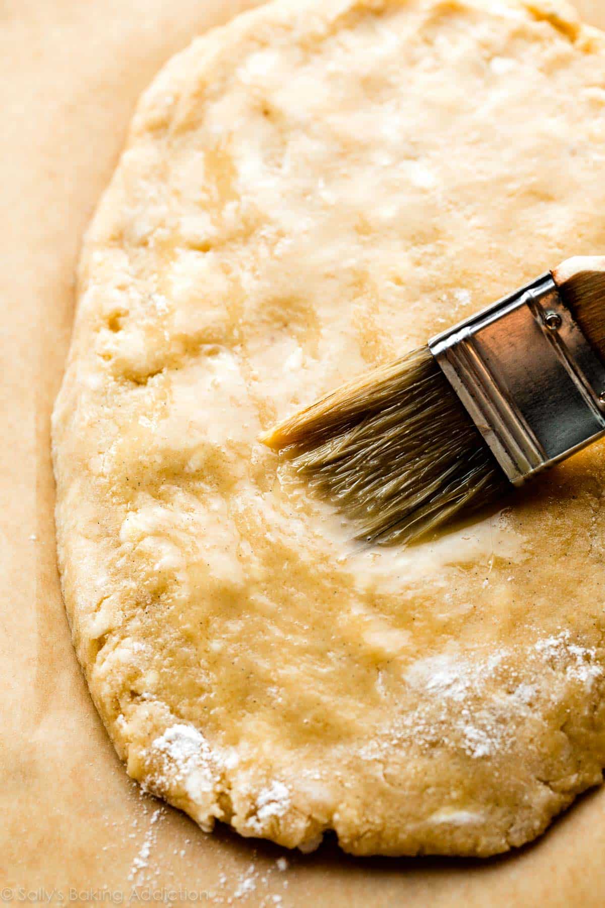 brushing egg wash on shaped biscotti dough slab