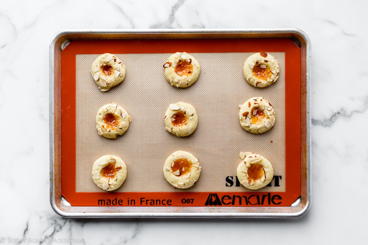 cream cheese thumbprint cookies with apricot jam on baking sheet