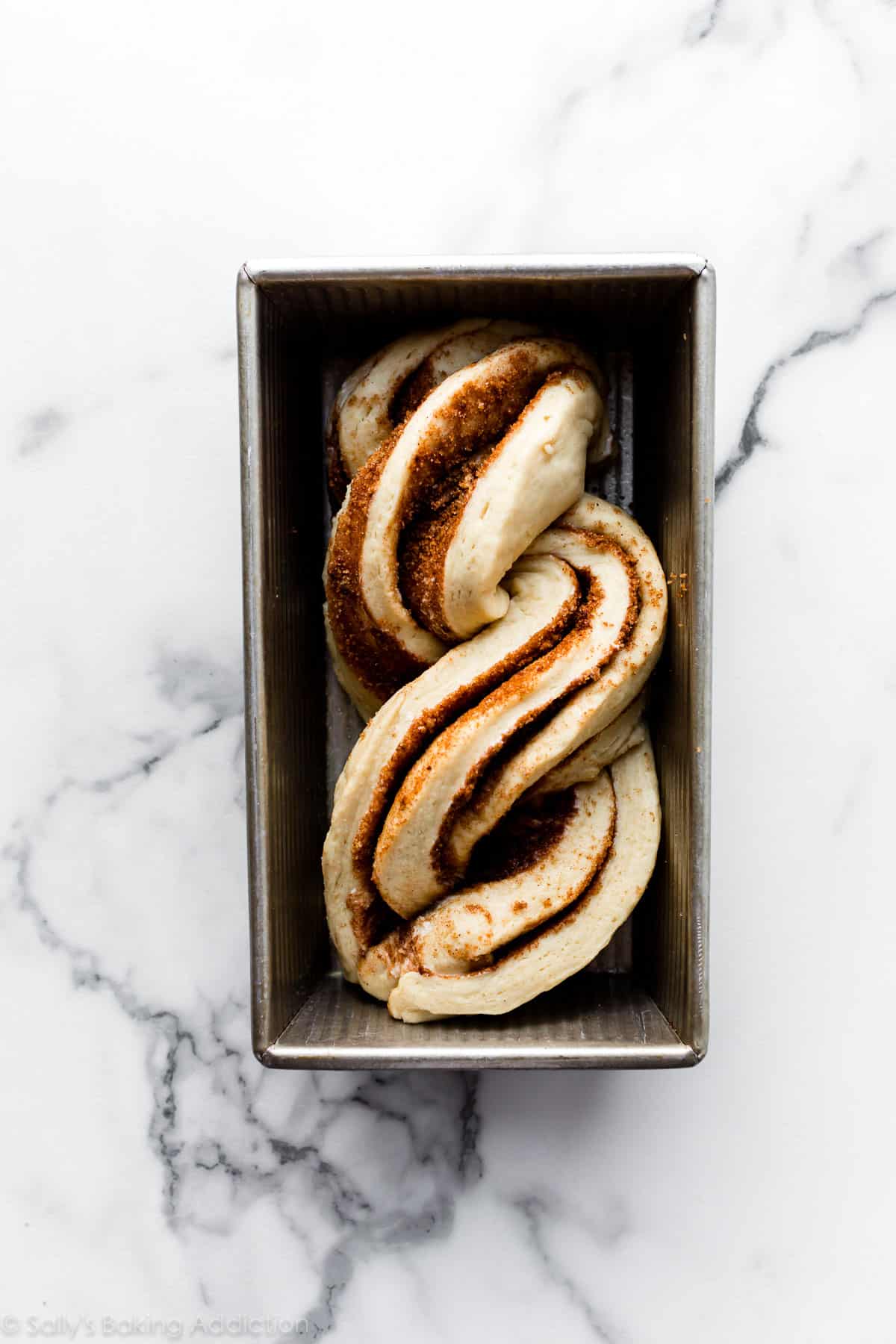 cinnamon twisted bread dough in loaf pan before rising