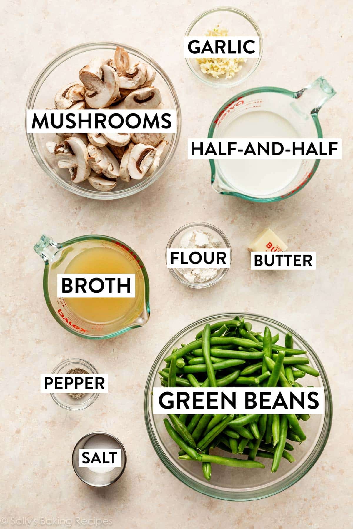 ingredients on peach surface including broth, half-and-half, butter, flour, garlic, and mushrooms.