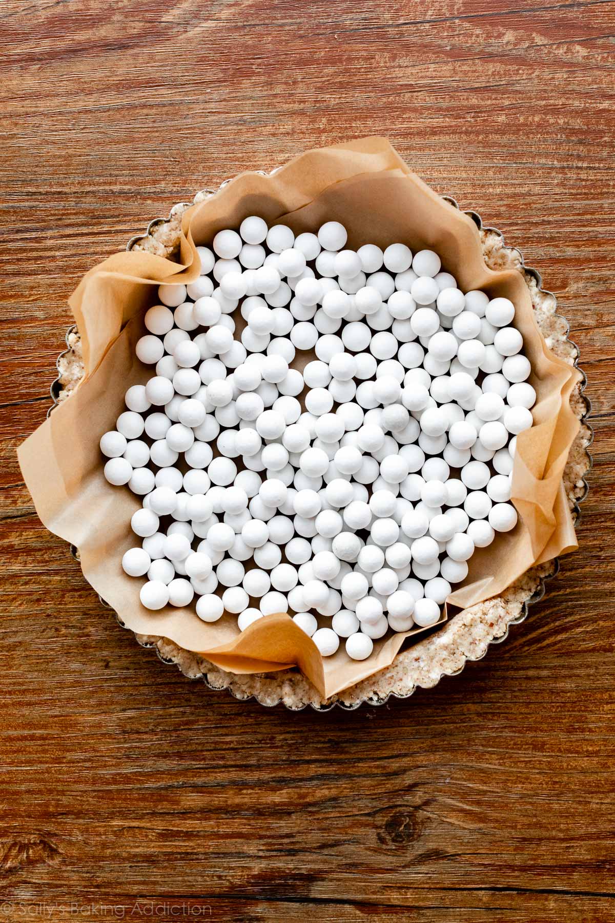 pecan crust in tart pan with pie weights