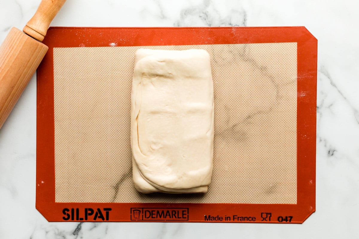 dough folded up on silicone baking mat lined baking sheet
