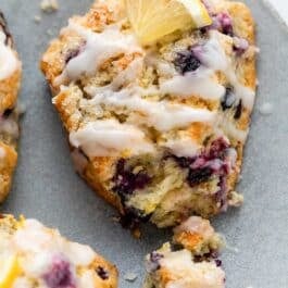 close-up of glazed lemon blueberry scone with bite taken out.