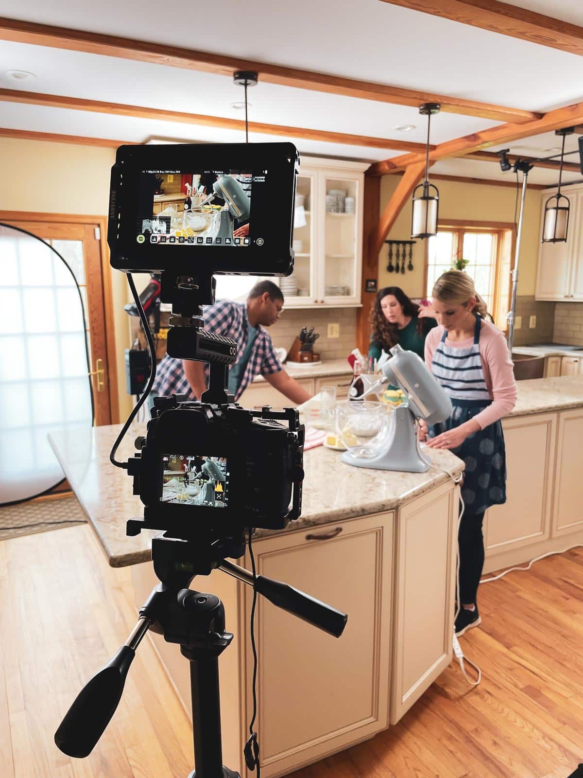 Sally in kitchen with photography lights and camera.