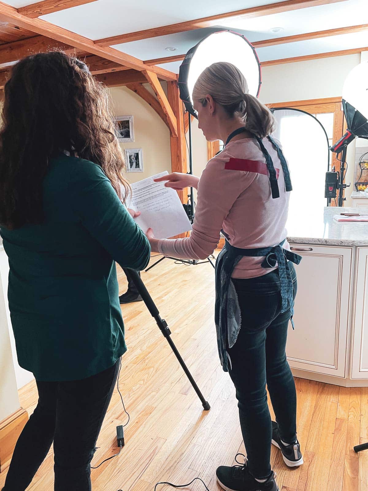 Sally in kitchen with notes for recipe videos.
