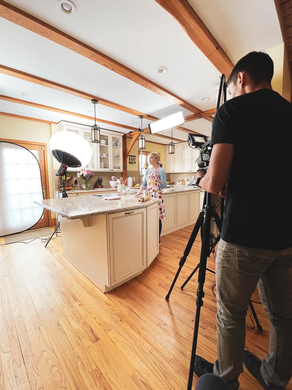 Sally in kitchen with photography lights and camera.