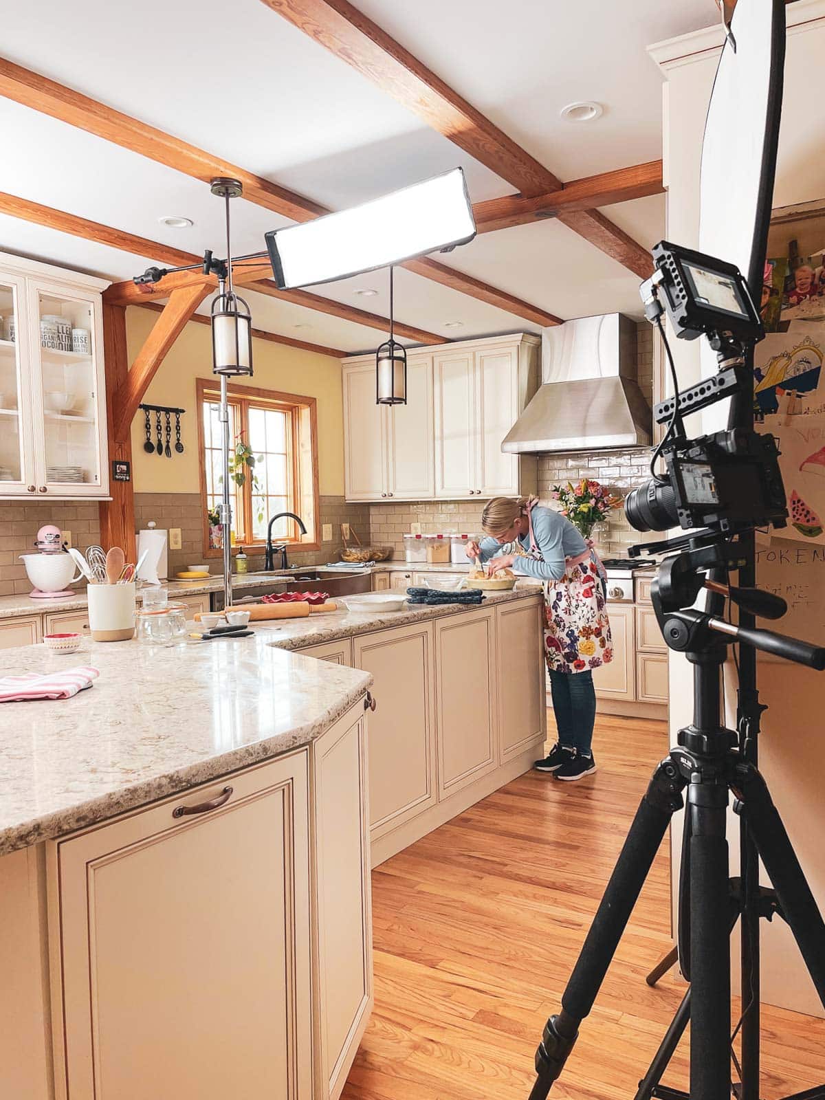 Sally in kitchen with photography lights and camera.