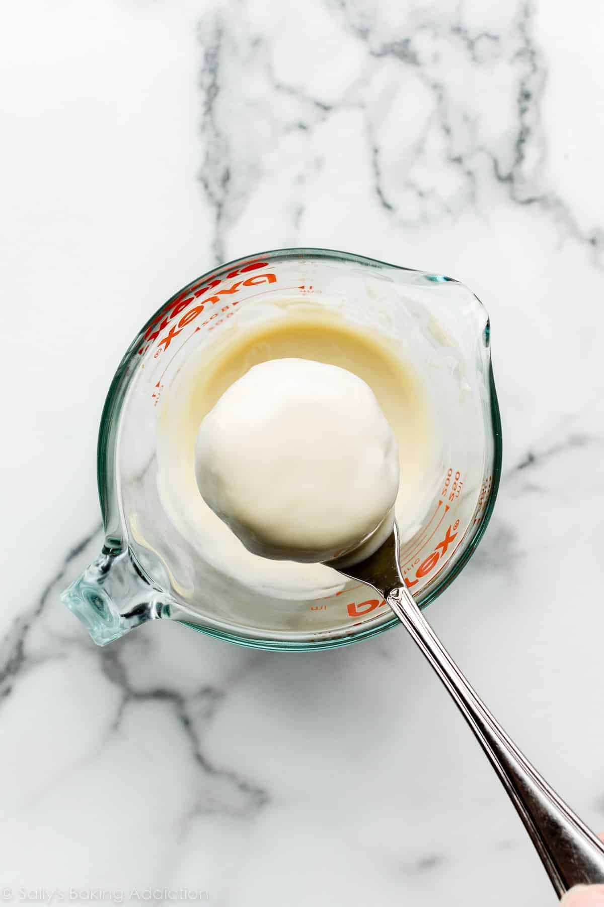 disc shaped cake pop dipped in white chocolate.
