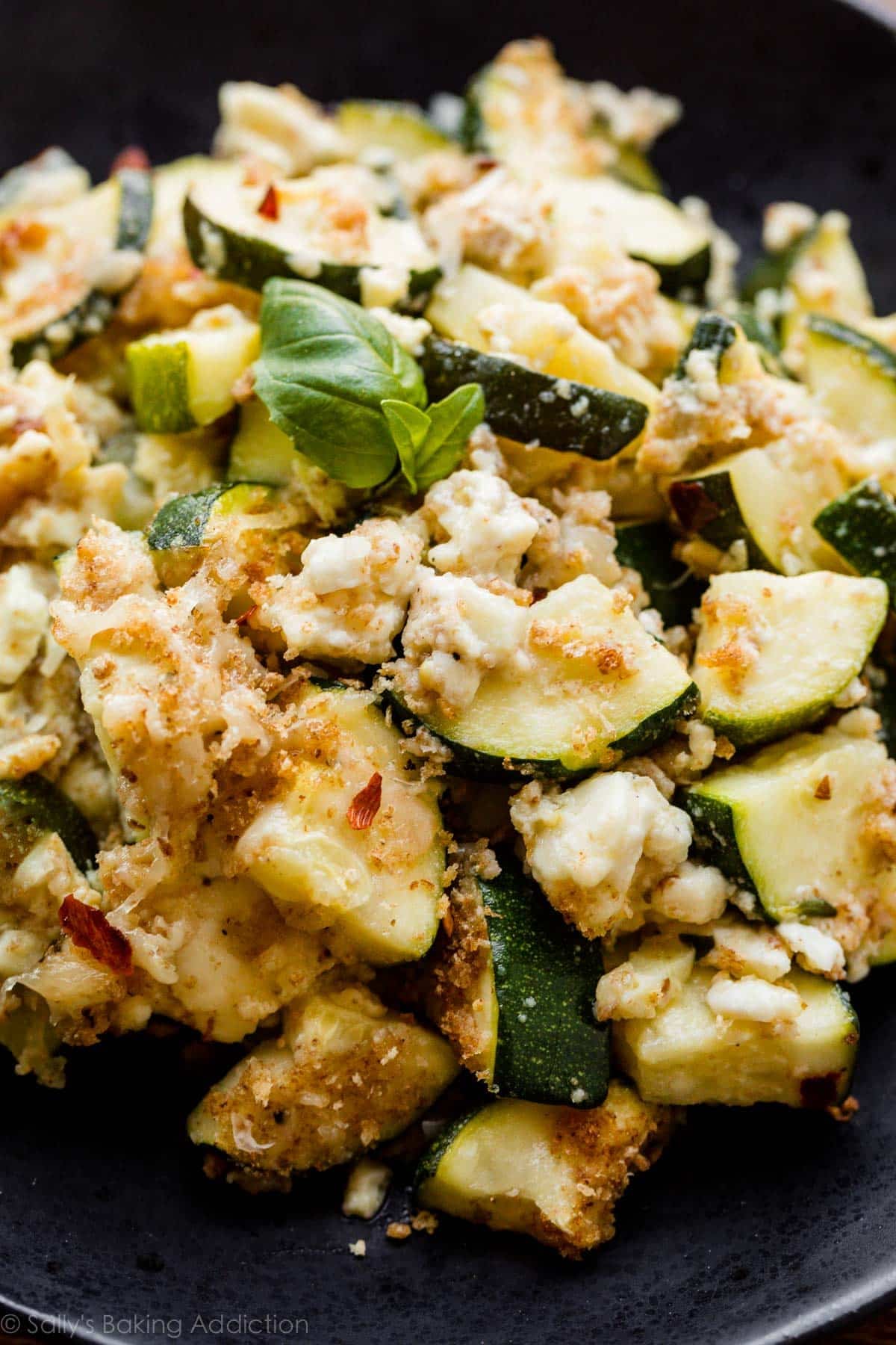 zucchini feta bake side dish serving on black plate