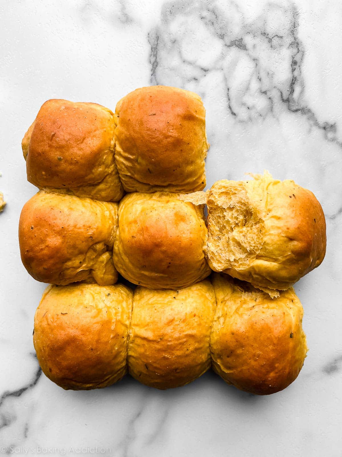 8 pumpkin rolls on marble counter.