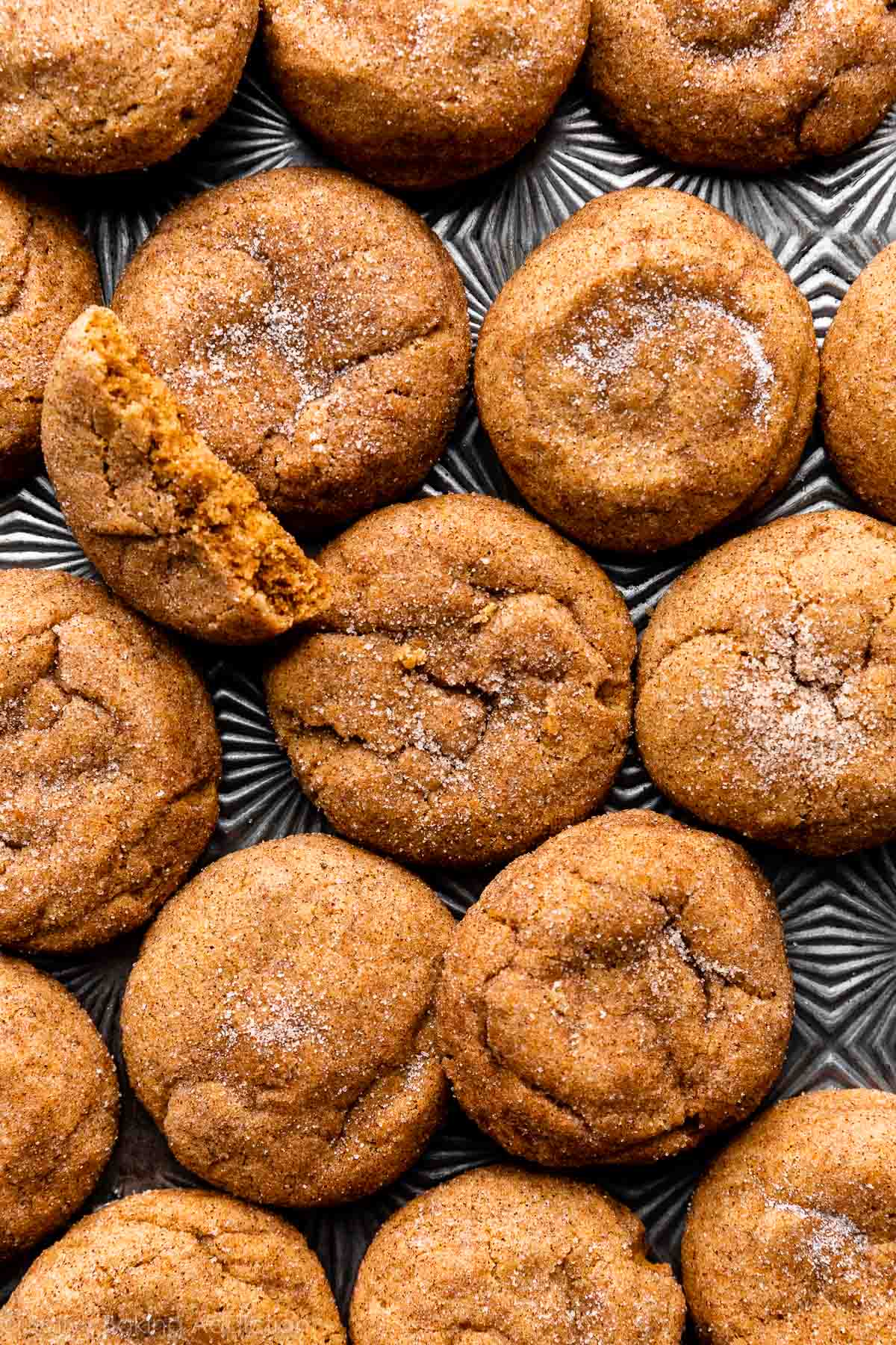 pumpkin snickerdoodles with cinnamon sugar topping on baking sheet.