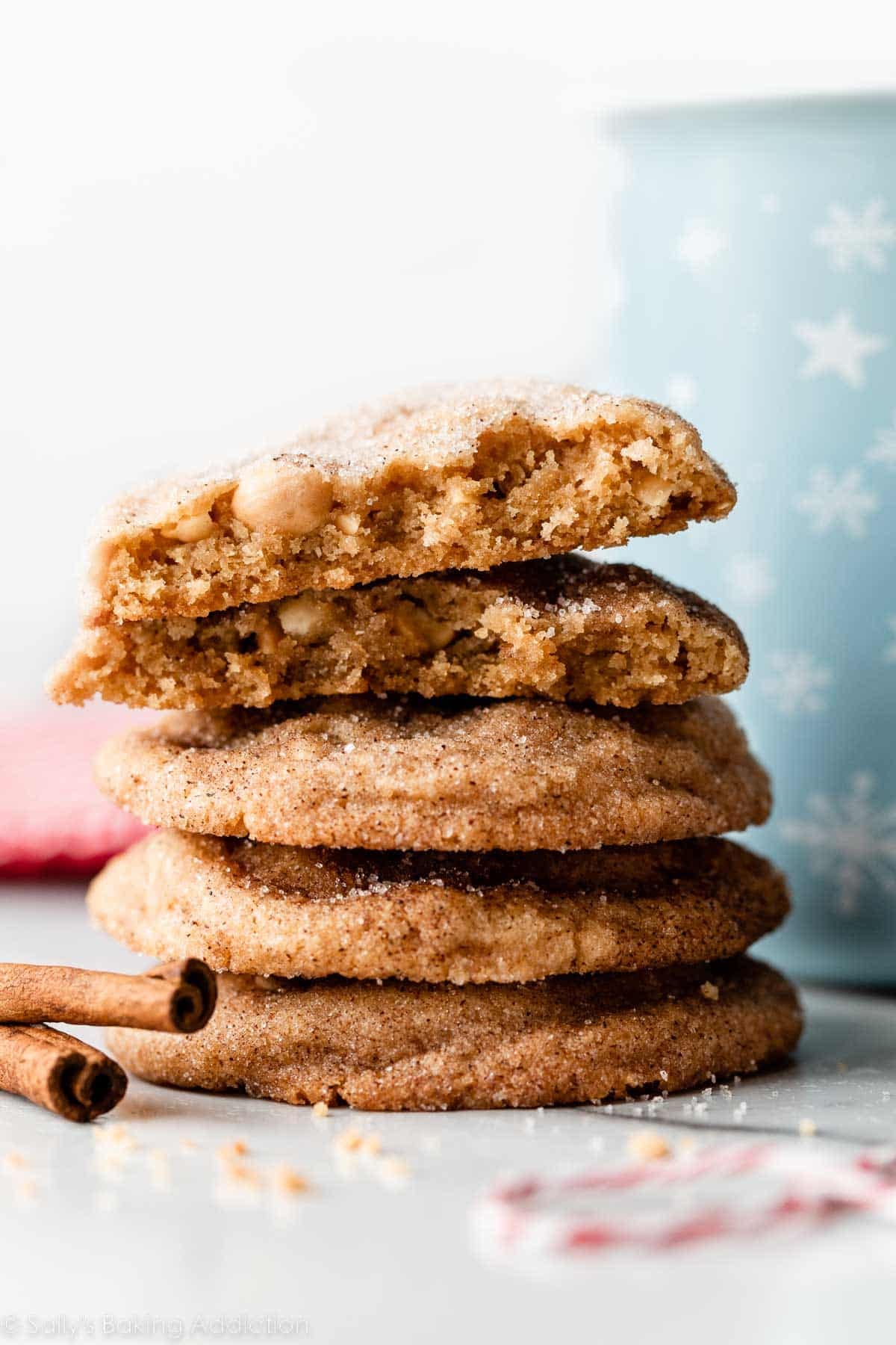 stack of peanut butter snickerdoodle cookies with blue snowflake mug behind it.