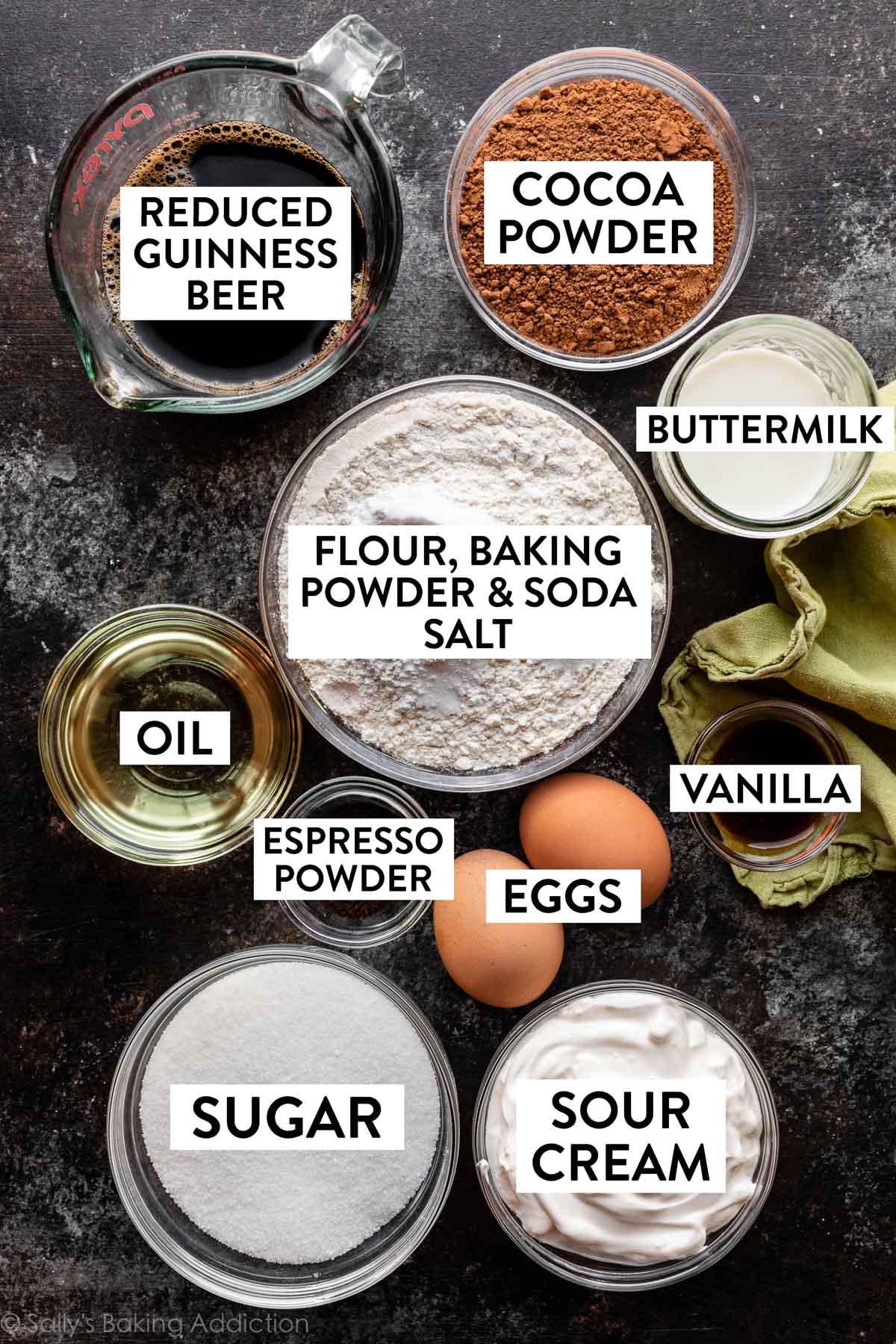 ingredients on dark backdrop including flour, buttermilk, cocoa powder, Guinness beer, sour cream, and more.