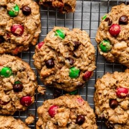 flourless Christmas-colored M&M monster cookies on wire cooling rack.