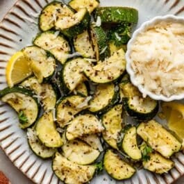 roasted lemon garlic zucchini pieces with parmesan on top.