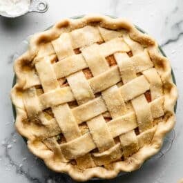 unbaked apple pie with lattice pie crust top and fluted edges.